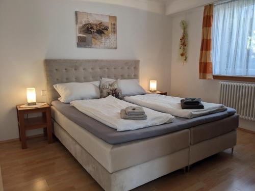 a bedroom with a bed with two lamps on it at im Oberdorf in Achern