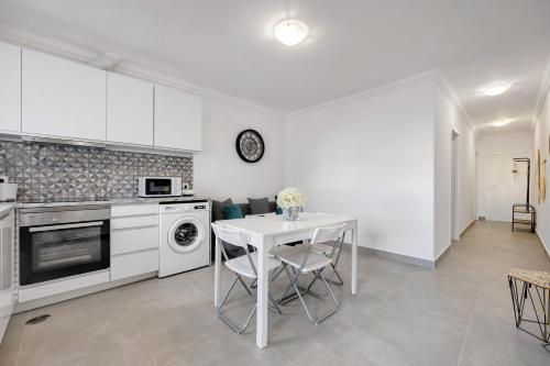 a kitchen with a white table and a white stove top oven at Yasmim House in Sagres