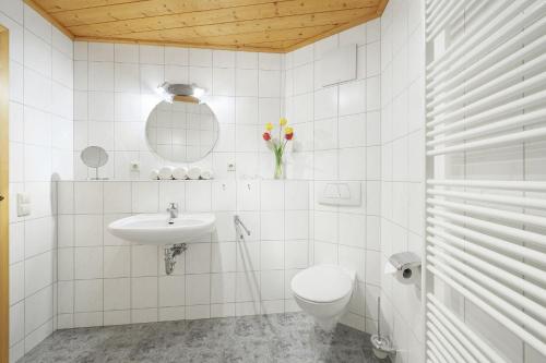 a white bathroom with a toilet and a sink at Winzerhof Wörner in Durbach