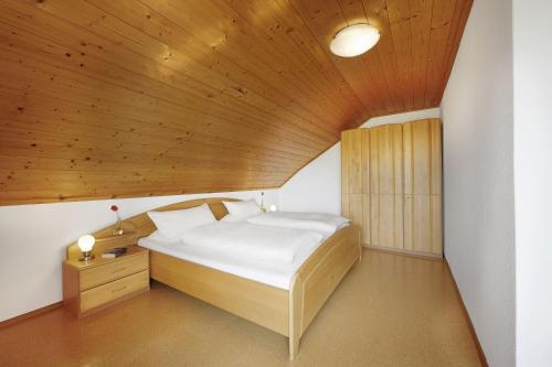 a bed in a room with a wooden ceiling at Winzerhof Wörner in Durbach
