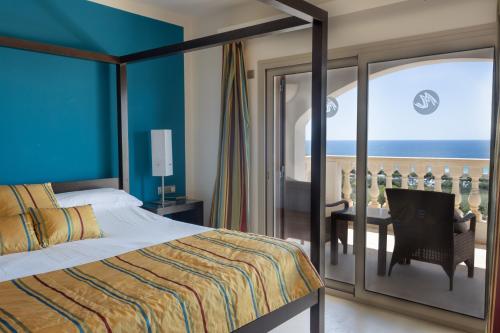 a bedroom with a bed and a view of the ocean at Villa Maitreya in Son Bou