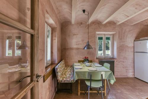 a dining room with a table and a kitchen at La Rectoría de Castellar in La Vall de Bianya