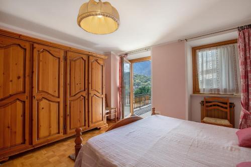 a bedroom with a large bed and a large window at Il Borgo - Aymavilles in Aymavilles