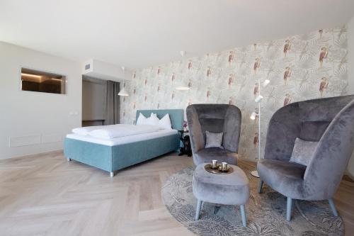 a bedroom with a bed and two chairs at Villa Gargnano in Gargnano
