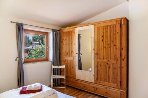 a bedroom with a wooden cabinet and a window at Haus Auner Top 4 in Westendorf