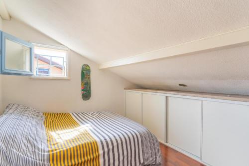 a small bedroom with a bed and a window at Charmant Studio Mezzanine in Biscarrosse