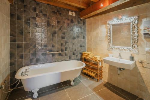 a bathroom with a tub and a sink at Astial Ezquerra - Casa Rural in Ezquerra