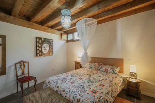 a bedroom with a bed and a chair at Astial Ezquerra - Casa Rural in Ezquerra