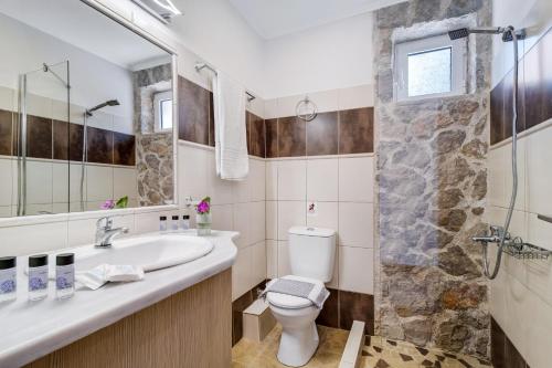 a bathroom with a toilet and a sink and a shower at Superior Apartment A in Tsoukalades