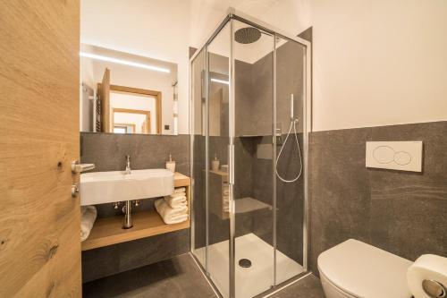 a bathroom with a shower and a sink and a toilet at Apt Zirbe - Nockerhof in Andrian