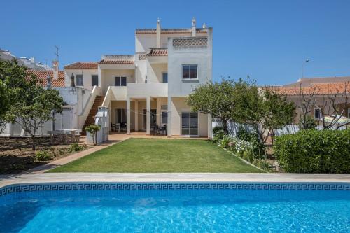 a villa with a swimming pool in front of a house at Villas Brites nº3 in Burgau