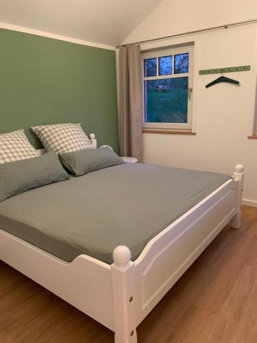 a white bed in a bedroom with a window at Das Sommerhaus in Zülow