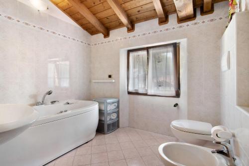 a bathroom with a tub and a toilet and a sink at Villa Adele in Gravedona