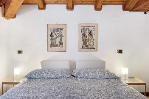 a bedroom with a bed with two pictures on the wall at Villa Adele in Gravedona