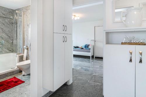a white bathroom with a toilet and a sink at See Oase in Uhldingen-Mühlhofen