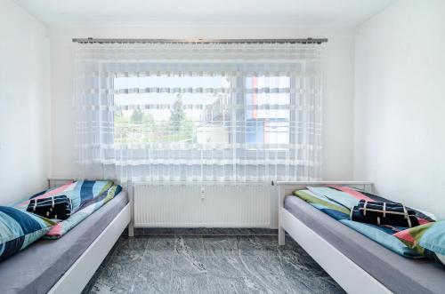 two beds in a room with a window at See Oase in Uhldingen-Mühlhofen