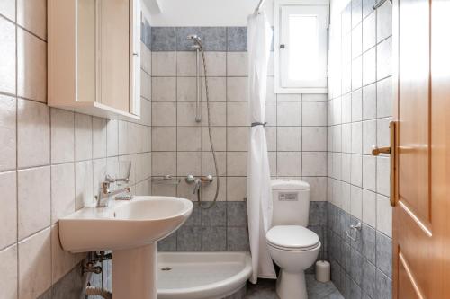 a bathroom with a sink and a toilet and a shower at Anemologio 203 Tinos in Agios Ioannis
