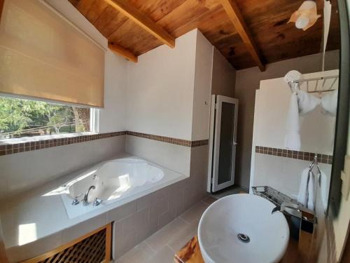 a bathroom with a tub and a toilet and a sink at ASGARD RESORT GUATEMALA in Santiago Sacatepéquez