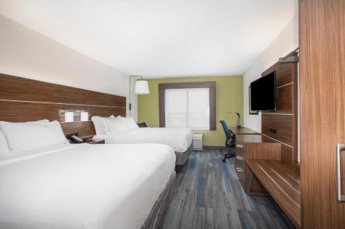 a hotel room with two beds and a television at Holiday Inn Express Kansas City - at the Legends! by IHG in Kansas City