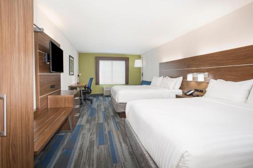 a hotel room with two beds and a television at Holiday Inn Express Kansas City - at the Legends!, an IHG Hotel in Kansas City