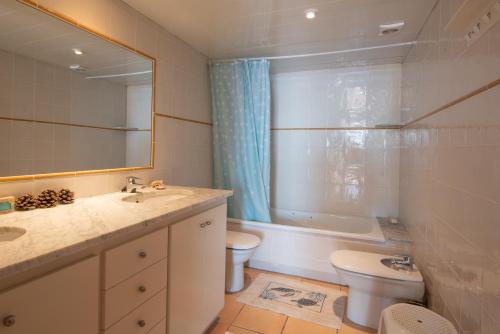 a bathroom with a sink and a toilet and a mirror at Casa Marbello - Begur in Begur