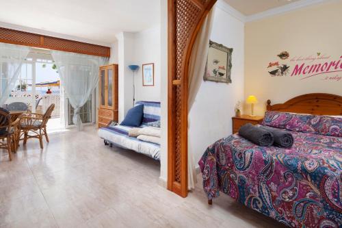 a bedroom with a bed and a dining room at Beachfront Bungalow in Torrox Costa