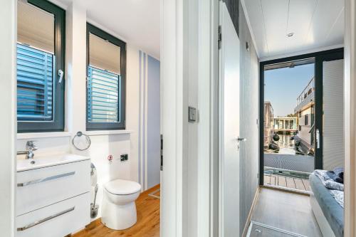 a bathroom with a toilet and a sink and a window at Hausboot Joana in Zehdenick