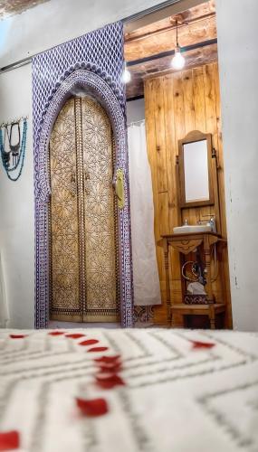 a bedroom with a large wooden door and a mirror at La Casa Arabe in Alcalá de los Gazules