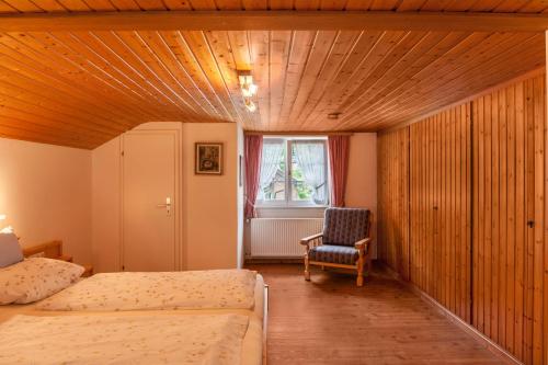 a bedroom with a bed and a chair and a window at Ferienwohnung Lengdobler - Burgi in Bad Kohlgrub
