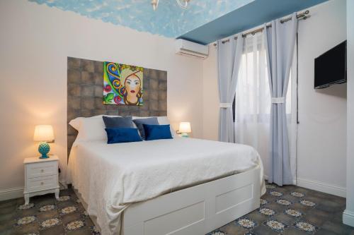 a bedroom with a large bed with blue pillows at A Ugghia- I Mori in Fiumefreddo di Sicilia