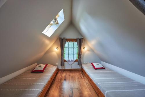 a attic room with two beds and a window at La Cidrerie in Cresseveuille