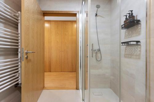 a shower with a wooden door in a bathroom at Vale viver in Vale de Cambra