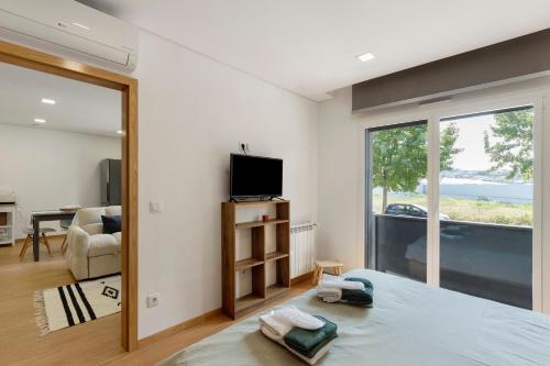 a bedroom with a bed and a large window at Vale viver in Vale de Cambra