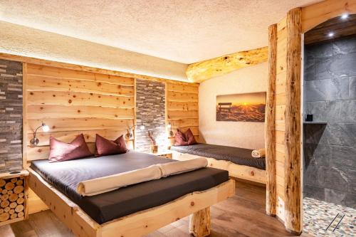 two beds in a room with wooden walls at Wegscheiderhof Apt Gartenwohnung in Velturno