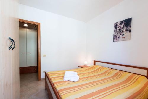 a bedroom with a bed with towels on it at Appartamenti Cavour codice F in Villasimius