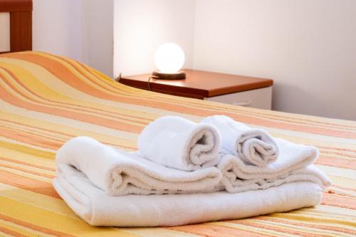 a pile of towels sitting on top of a bed at Appartamenti Cavour codice F in Villasimius