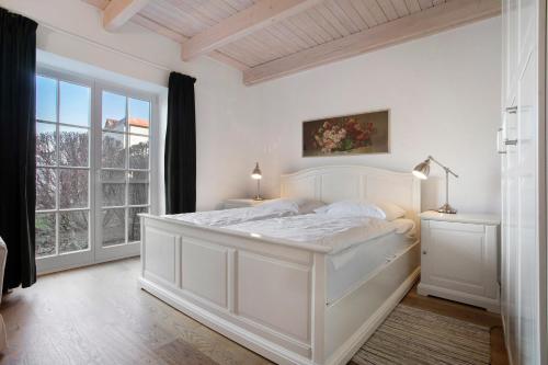 a white bedroom with a bed and a window at Haus Herr Krug in Walkendorf