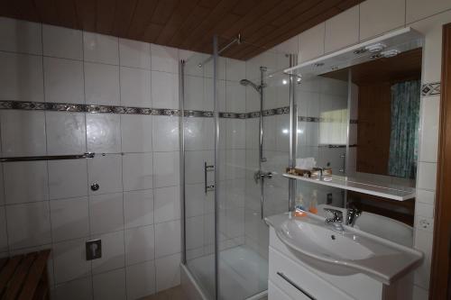 a bathroom with a glass shower and a sink at Gästehaus Heimenberg in Bad Rippoldsau-Schapbach