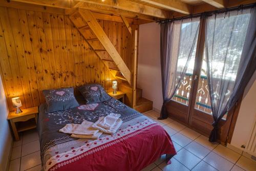 a bedroom with a bed and a large window at Chalet la savoyarde in Châtel