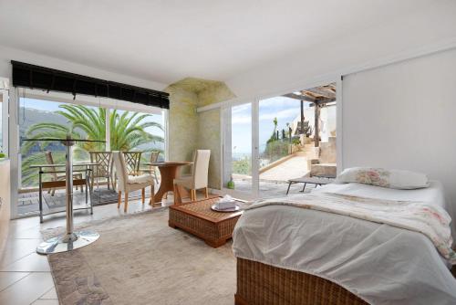 a bedroom with a bed and a balcony with a table at Piso Loft tropical Doa in San Marcos