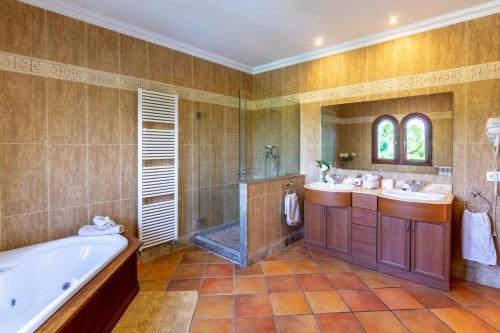 a bathroom with two sinks and a tub and a shower at Can Sanchez in Campos