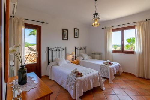 a bedroom with two beds and a table and a window at Can Sanchez in Campos