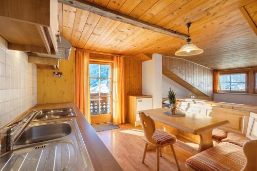 a kitchen with a wooden ceiling and a wooden table at Jelerhof in Gsies