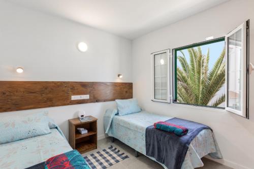 a bedroom with two beds and a window at Salitre Tea in Los Cancajos