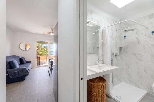 a white bathroom with a sink and a shower at Salitre Tea in Los Cancajos