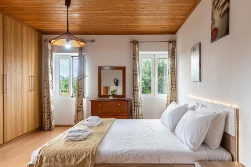 a bedroom with a large bed with white sheets and pillows at Serenity Paxos in Gaios