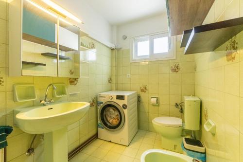 a bathroom with a sink and a washing machine in it at Serenity Paxos in Gaios