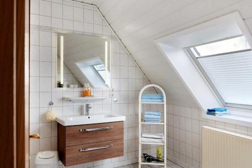 a bathroom with a sink and a mirror at Ferienhaus Poth in Wangerland