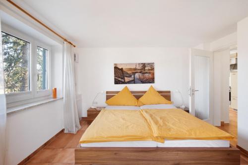 a bedroom with a large bed with yellow sheets at Birkethof Teichblick in Grimoldsried
