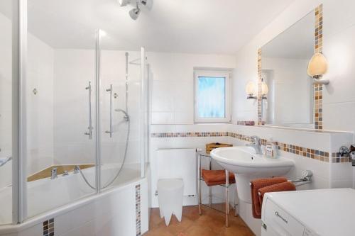 a white bathroom with a shower and a sink at Birkethof Teichblick in Grimoldsried